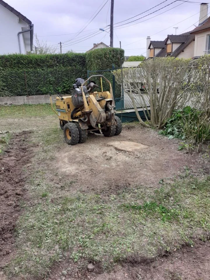 Rotor dessouchage mécanique en action dans un jardin pavillonnaire